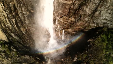 A-close-up-capture-of-Bridalveil-Falls-featuring-a-rainbow-forms-a-ring-like-effect-at-the-base-of-the-waterfall