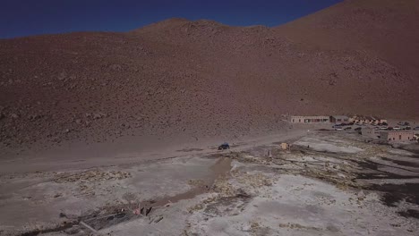 aéreo siguiendo el coche moviéndose a lo largo del desolado, estéril y hermoso paisaje en bolivia