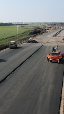 road construction with asphalt paving and heavy machinery