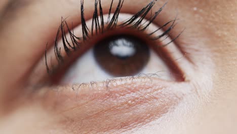 Primer-Plano-Del-Ojo-De-Una-Mujer-Birracial-Con-Cabello-Oscuro,-Cámara-Lenta