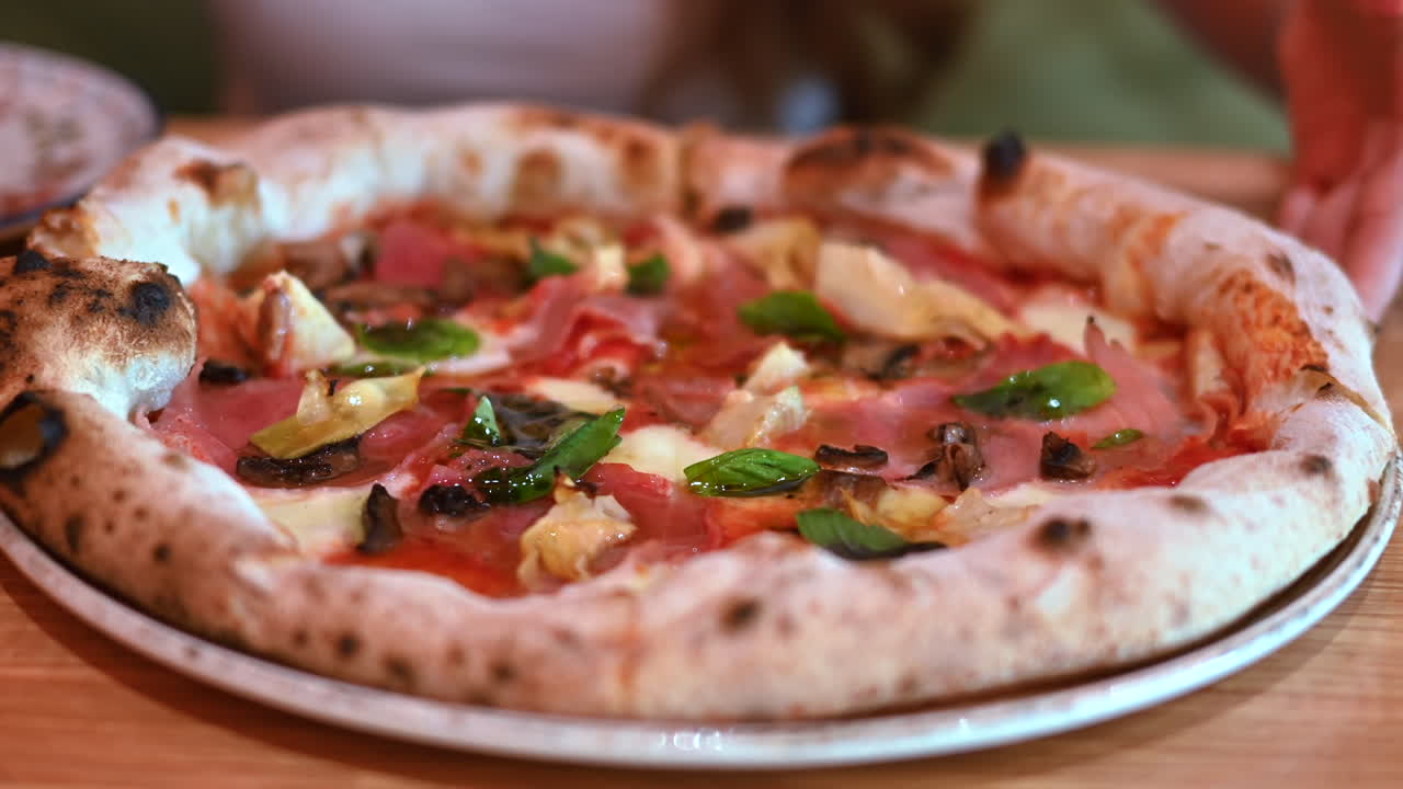 Pizza con funghi, prosciutto e carciofi, primo piano