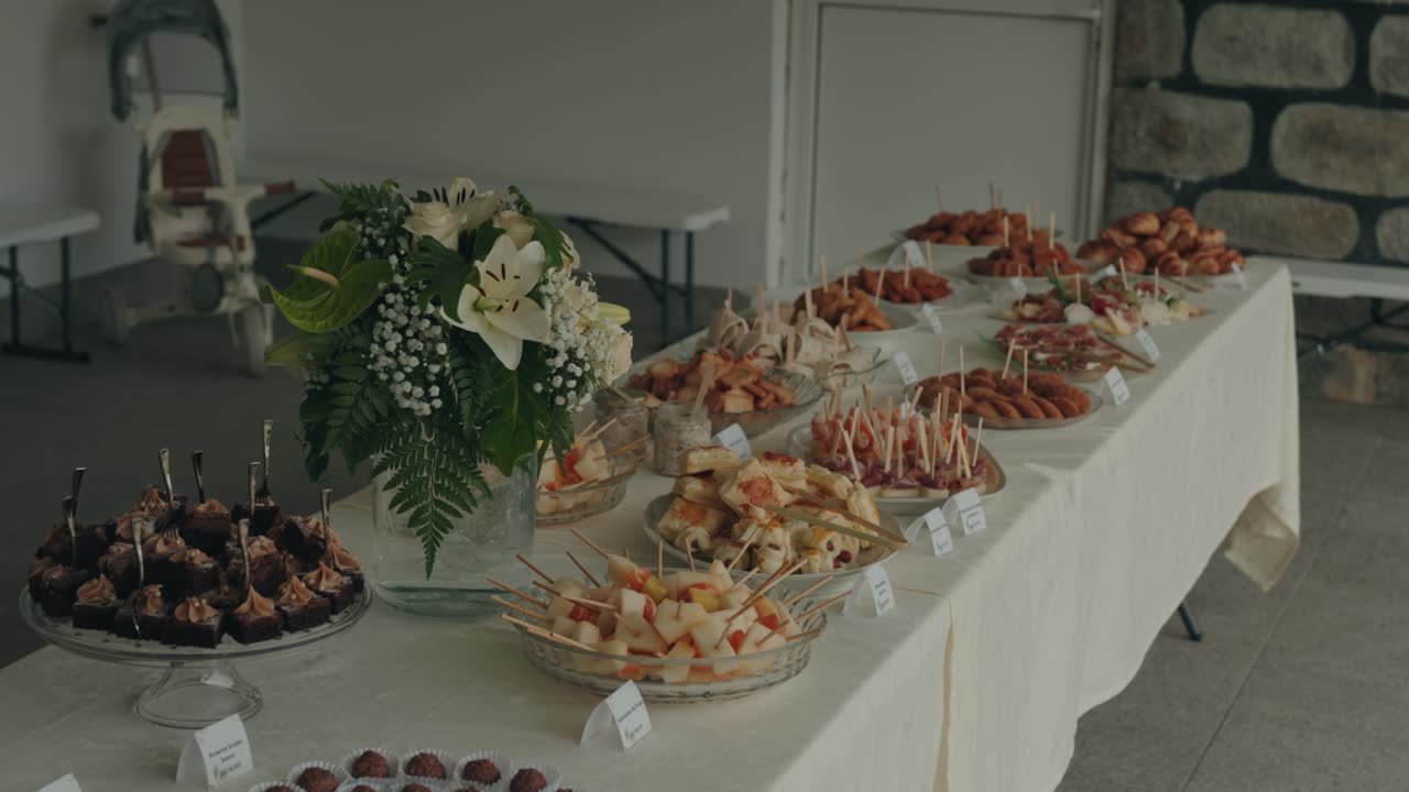 Tavolo da buffet catering con antipasti e fiori all'interno.