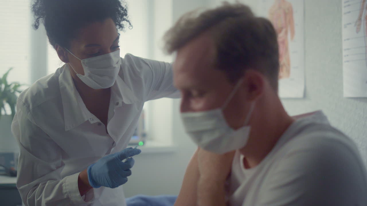 Guy getting covid vaccination in office clinic close up. Doctor making injection