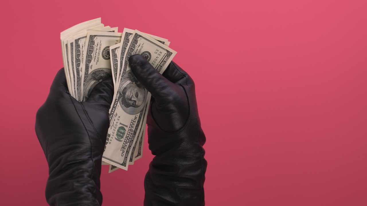 Behandskede hænder tæller stakke af amerikanske dollar-sedler