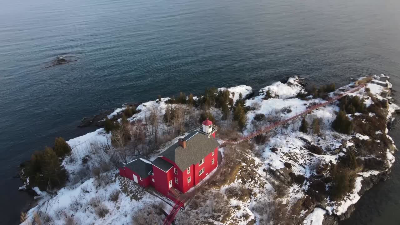 Kışın Marquette, Michigan'da bulunan kırmızı deniz feneri, döner drone çekimiyle