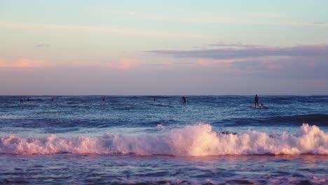 Mehrere-Surfer-Am-Meer-Während-Der-Abenddämmerung