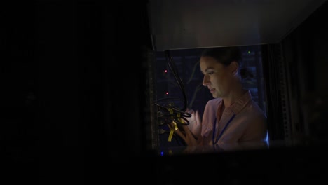 técnica informática caucásica que usa una tableta para comprobar el servidor de la computadora