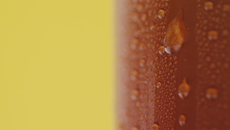 Close-Up-Of-Condensation-Droplets-Running-Down-Takeaway-Can-Of-Cold-Beer-Or-Soft-Drink-Against-Yellow-Background-1