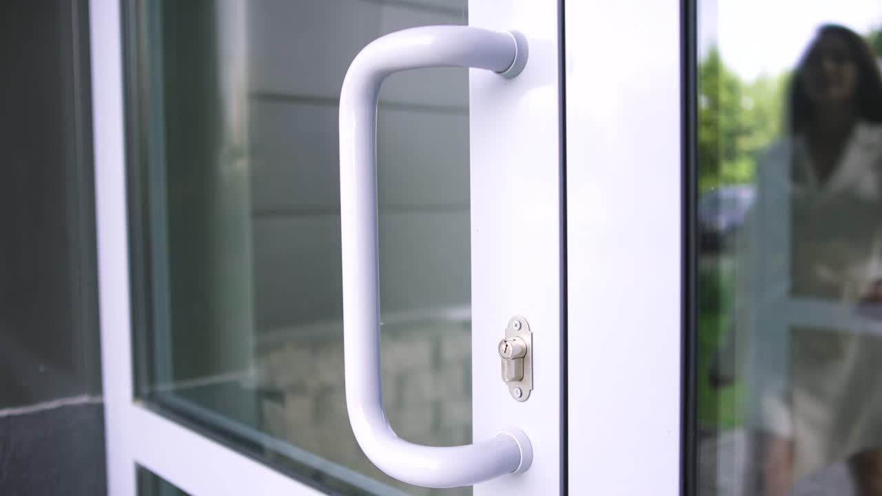 Donna che apre una moderna porta a vetri