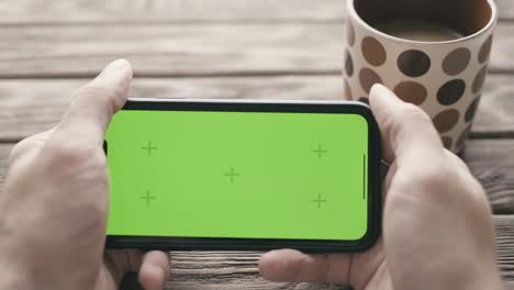 man using smartphone with green screen chroma key.