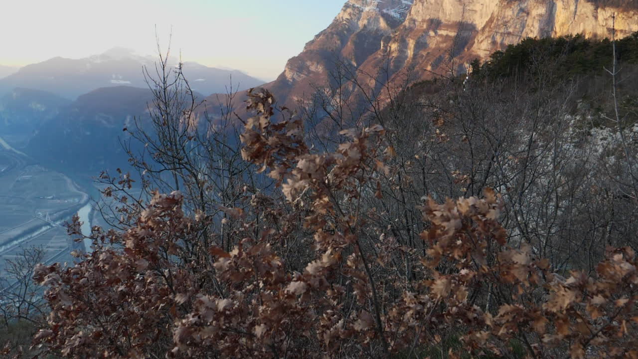 Sun illuminated mountain peaks and a river valley in the Trentino region of Italy