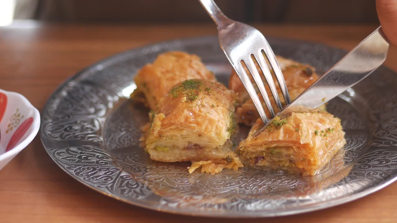 Mangiare Baklava con forchetta e coltello