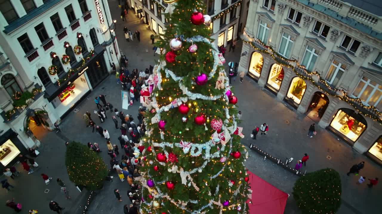 Panning camera descending after opening aerial shot over plaza, revealing Christmas tree and crowd