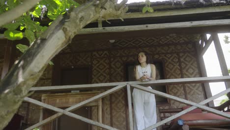 Young-pretty-brunette-woman-observing-jungle-form-room-balcony