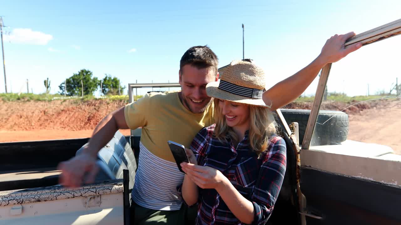 pareja tomando una selfie con un teléfono móvil en un coche 4k