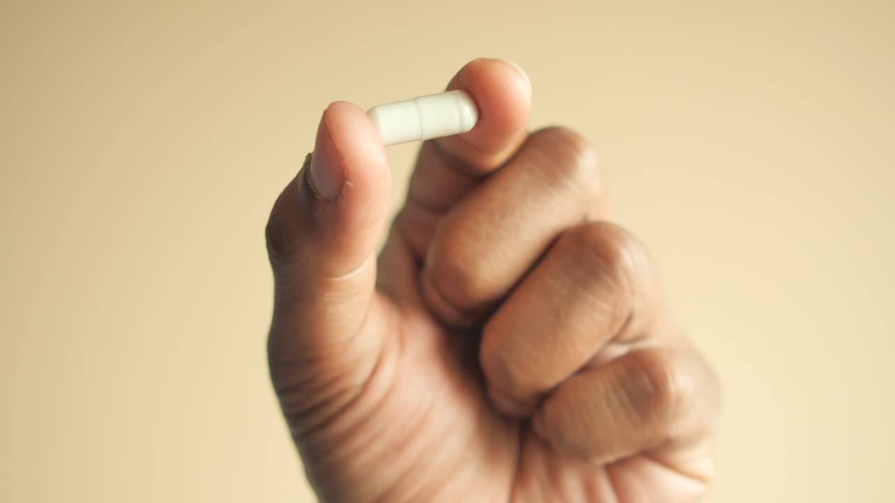 색 알약 을 들고 있는 손