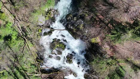 una imagen estática de un dron aérea captura el agua que fluye de la cascada de seerenbachfälle, ubicada en el corazón de los alpes suizos en amden-betlis, a orillas del lago walensee, suiza.