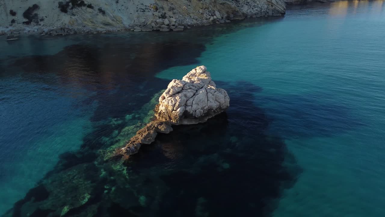 Drone Aereo che Orbita Attorno a una Formazione Rocciosa Bianca nel Sud Sardegna al Tramonto