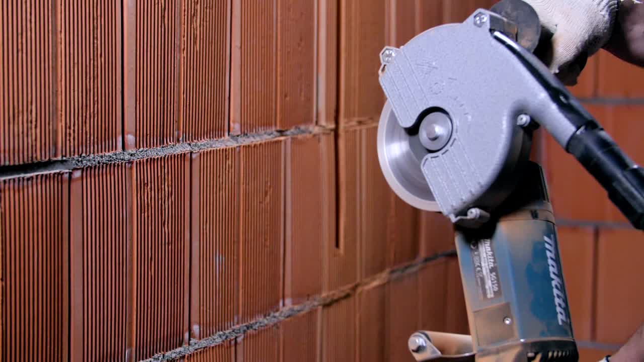 전력 도끼로 벽돌 벽을 잘라내고