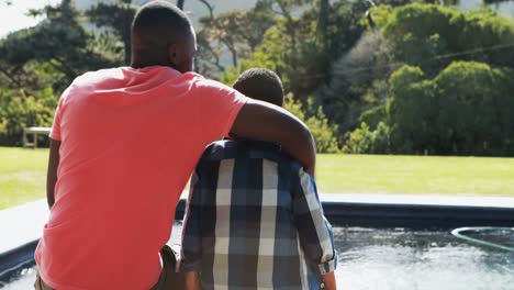 father talking to son near pool side