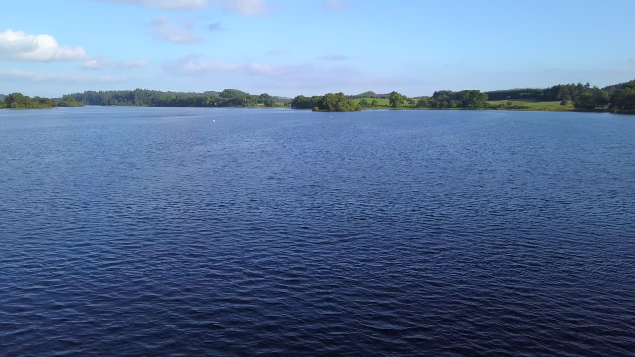 el dron vuela bajo sobre el lago ken, dumfries, escocia.