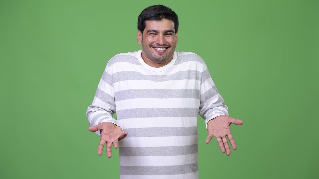 Young handsome Persian man shrugging shoulders