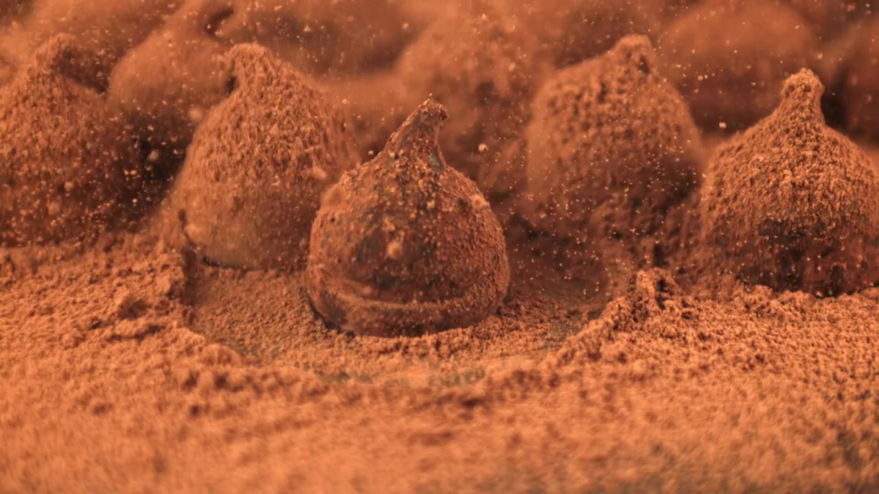 Slow Motion Chocolate Truffle Falling into Cocoa Powder