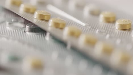 video of close up of yellow tablets on pink background