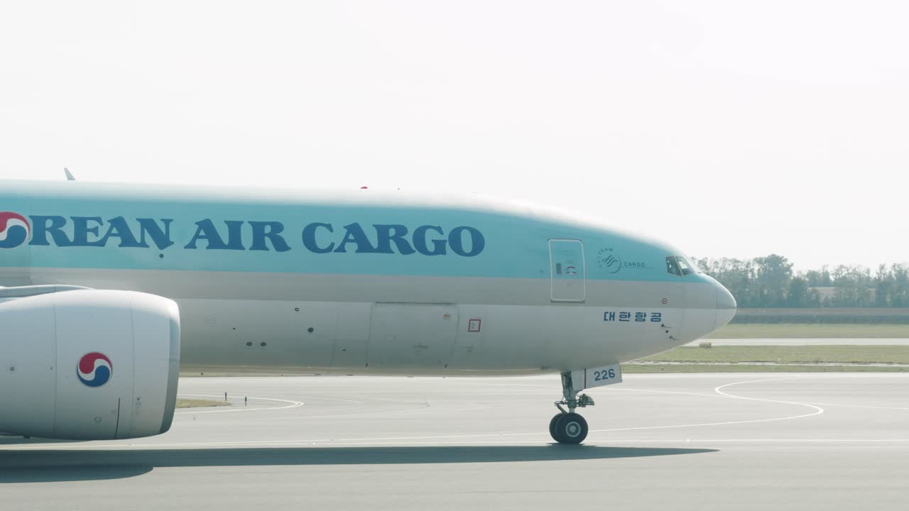 A massive Korean Air Cargo plane is taxiing into the ramp in Vienna International Airport