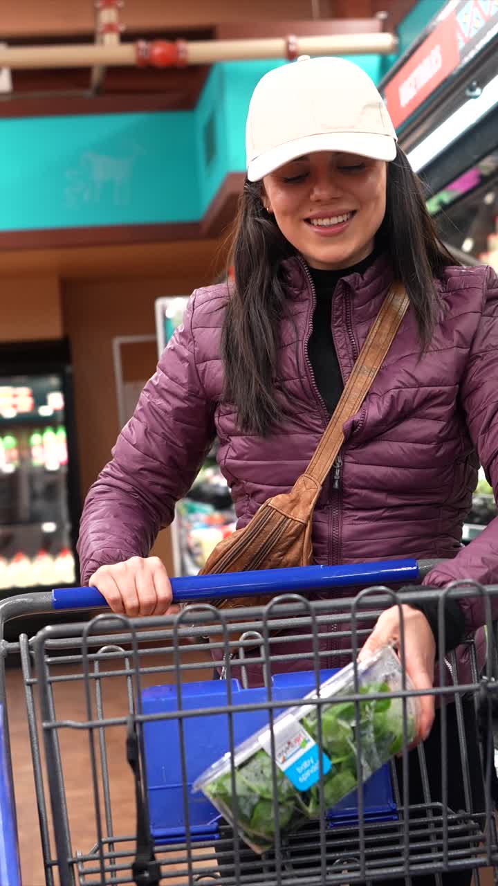 Mujer joven feliz comprando productos frescos en un supermercado