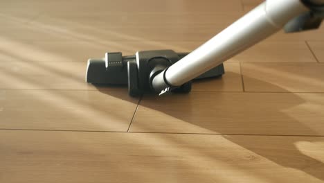 close-up of a vacuum cleaner cleaning a wooden floor