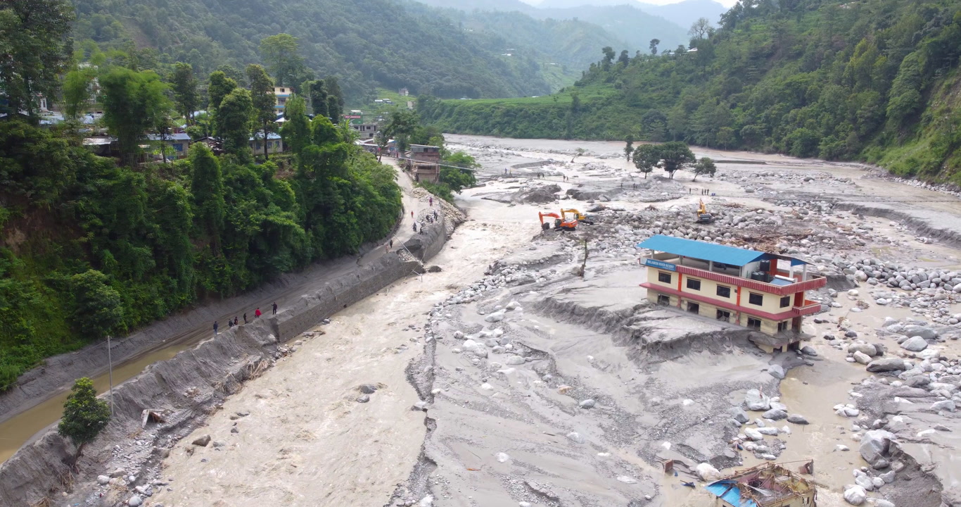 Drone shot of abandoned houses stranded within the Melamchi River after monsoon flooding, showing severe damage and isolation in Nepal.