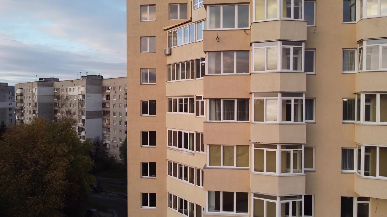 Letecký pohled na dron letící nad budovami, záběry střech a architektury.