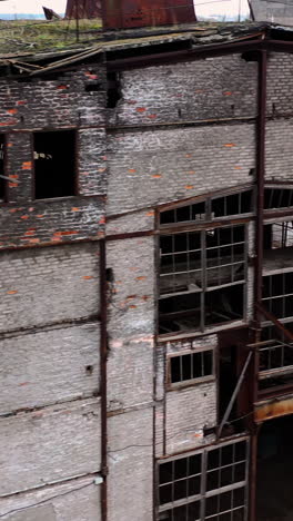 abandoned building during war time. destroyed building with broken windows. exterior of ruined architecture. vertical video