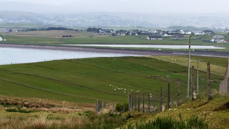 Shot-of-crofts-and-fields-around-Point-as-well-as-The-Braighe-road-near-Stornoway,-which-is-visible-in-the-distance