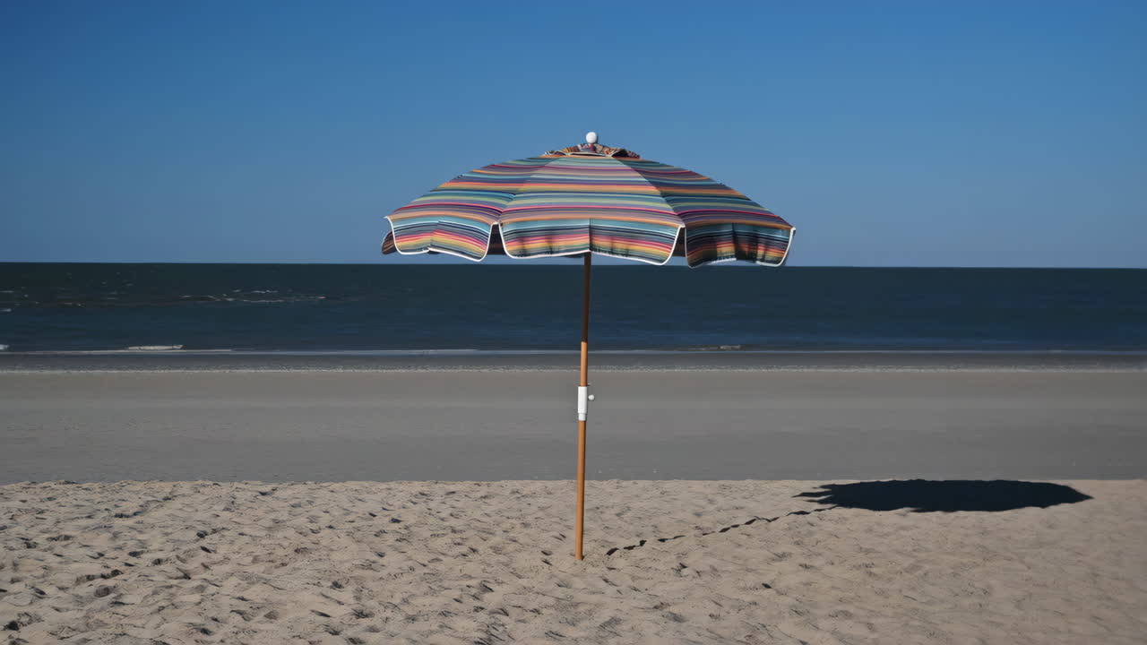 Colorful Striped Beach Umbrella on a Serene Beach