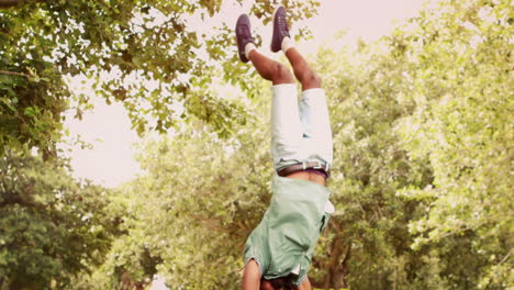 En-Cámara-Lenta,-Un-Joven-Bailarín-De-Break-Haciendo-Back-Flip-En-El-Parque.