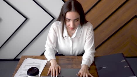 a woman is working with her laptop in an office 3