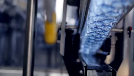 fast moving empty bottles transferred above conveyor belt.