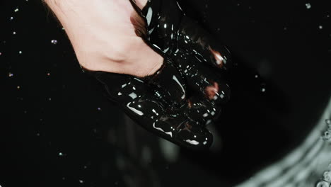 hand covered in black oil
