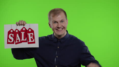 cheerful man showing sale word and showing up to 70 percent off inscription. black friday concept