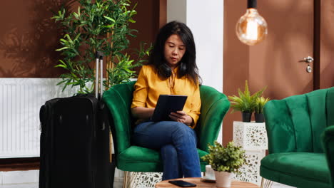 Young-traveler-using-tablet-in-lounge-area-at-hotel