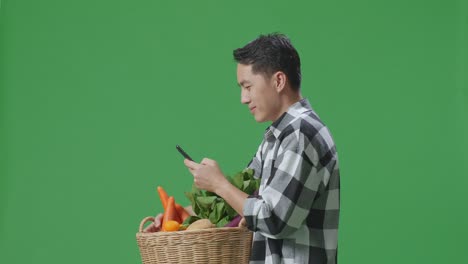 hombre comprando verduras usando un teléfono móvil