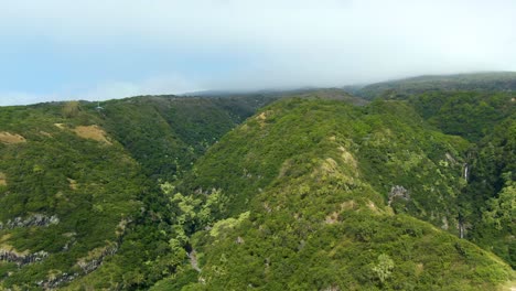 Wide-aerial-of-foggy-green-mountains-by-Alelele-Bridge-on-Maui,-Hawaii