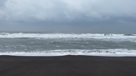 waves crashing on beach in yogyakarta, indonesia - static shot on overcast day