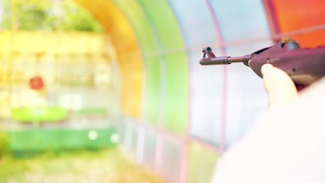 close-up young guy shoots at shooting gallery from an air rifle