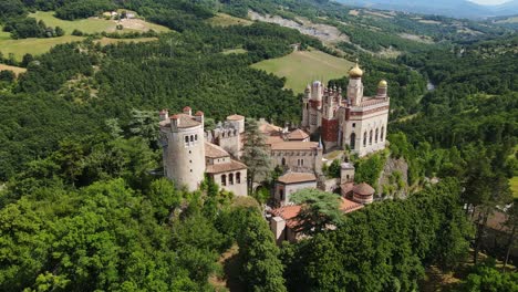 drone backward, revealing unique architecture of rocchetta mattei in apennines
