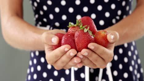 Mid-section-of-woman-holding-strawberries