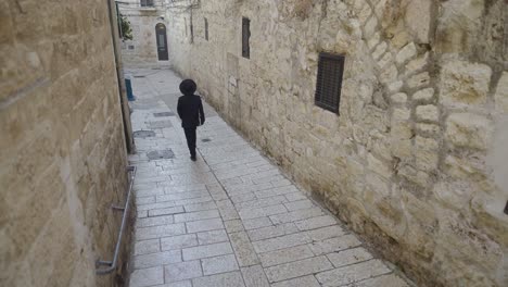 orthodox jewish man walks through the jewish quarter