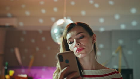 upset woman texting mobile phone after night party closeup. serious girl looking